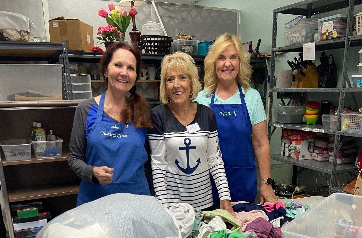 Three volunteers sorting donations in the back room